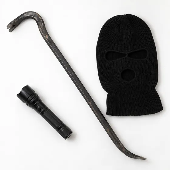 Crowbar, black ski mask and a flashlight on a white background